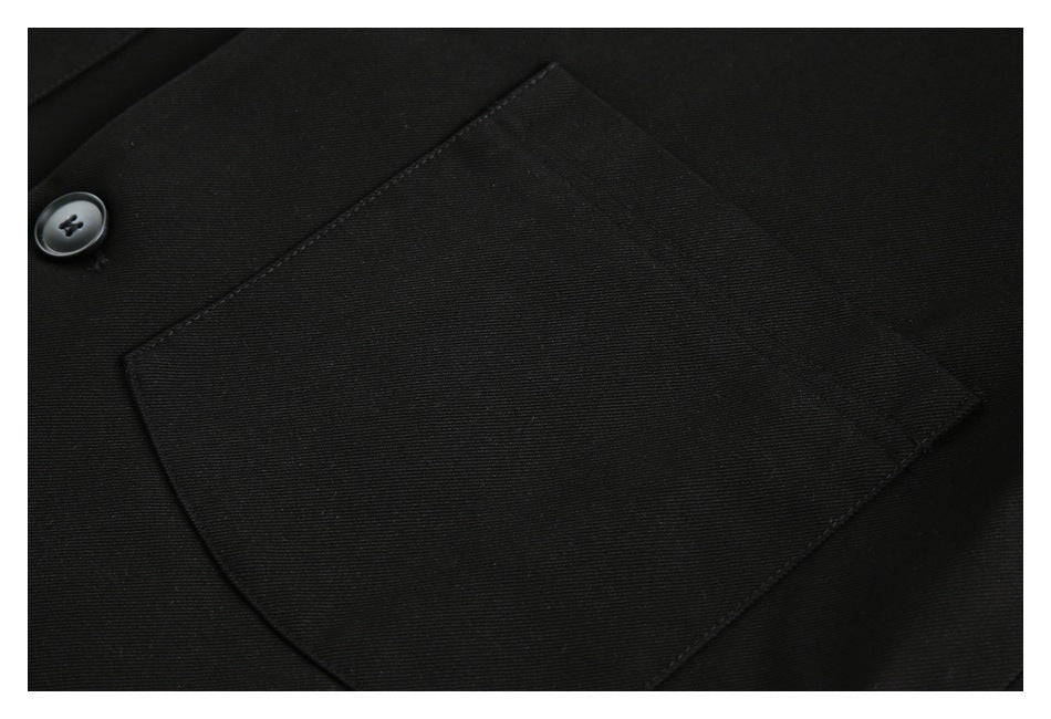 Close-up of a large patch pocket and button on the front of the black jacket.