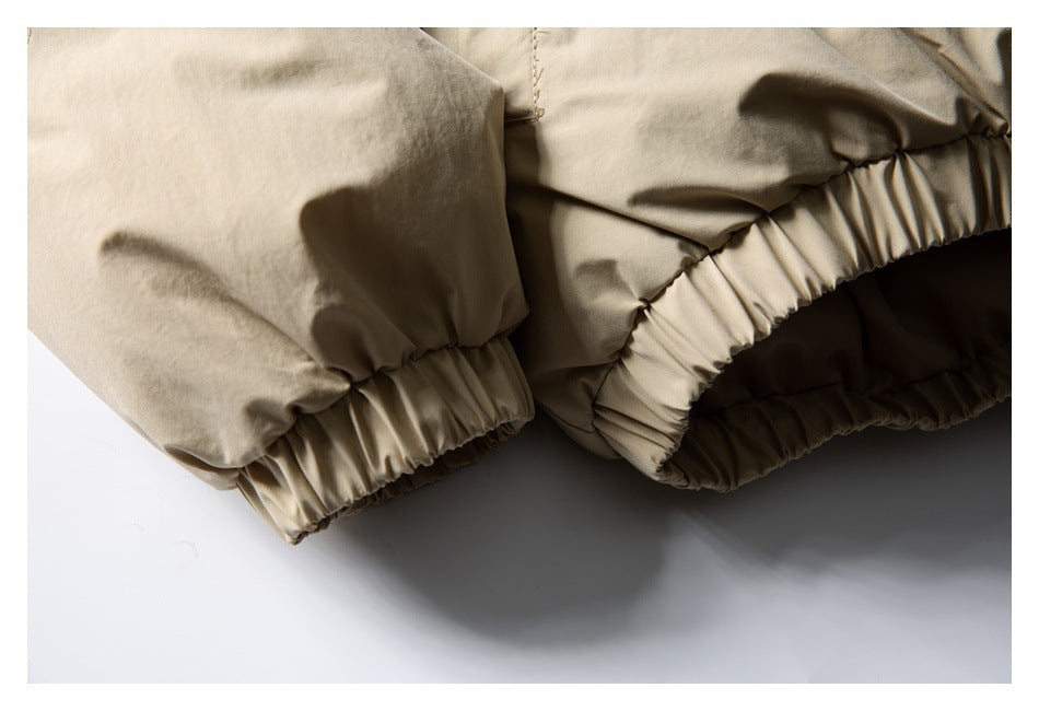 Close-up of a tan jacket’s gathered elastic sleeve cuff and hem.