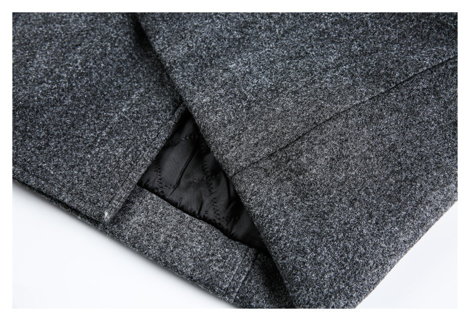 Close-up of an opening in the charcoal-gray coat showing dark lining and stitched detailing.