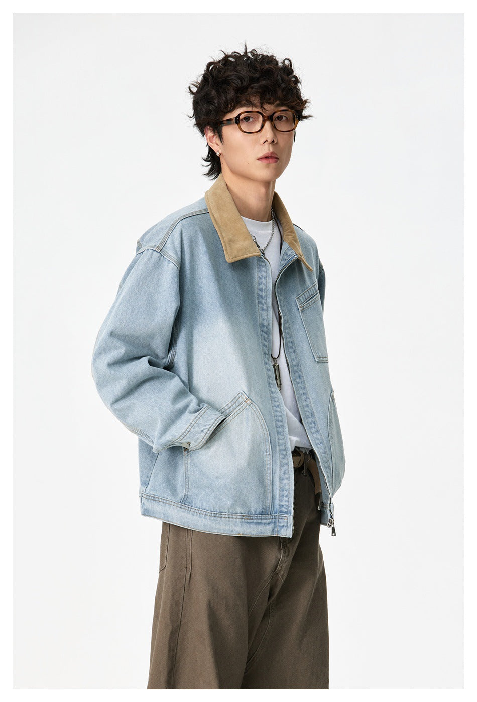 Three-quarter view of a model wearing a light-wash denim jacket with a tan collar and zip front.