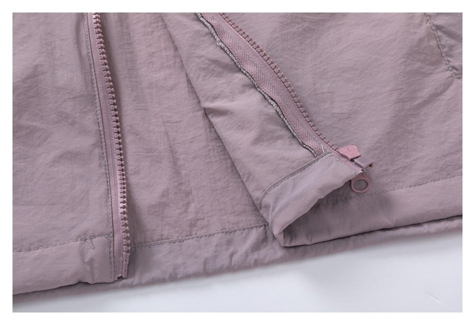 Close-up of a mauve zipper, stitching, and folded fabric edge.
