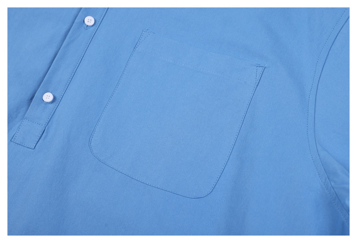 Close-up of a blue shirt’s front chest pocket and button placket with white buttons.