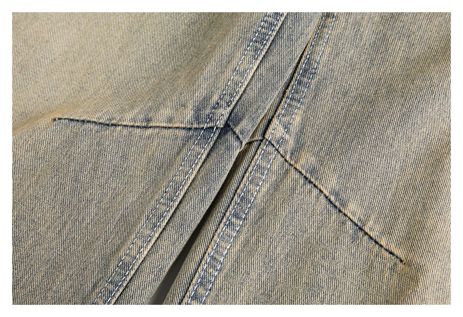 Close-up of overlapping stitched seams on tan denim jeans.