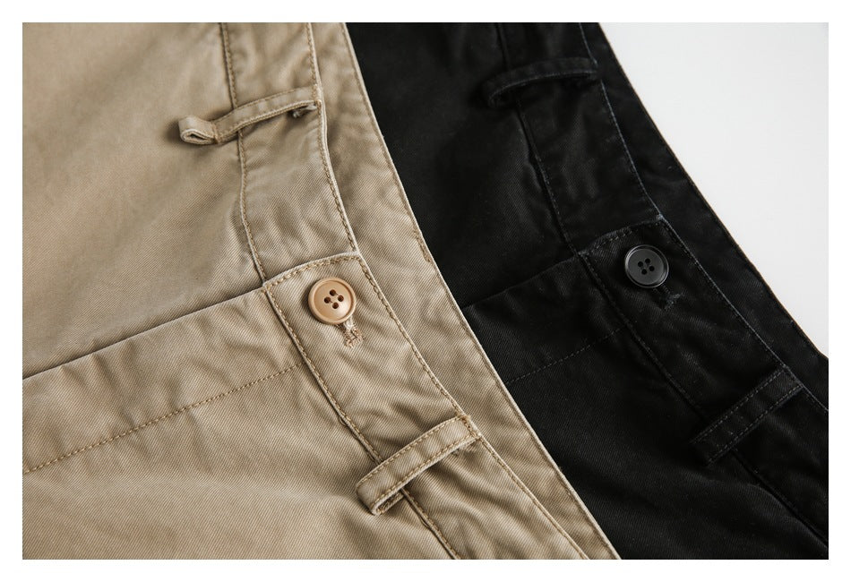 Close-up of tan and black trousers showing buttons, belt loops, and stitched waistbands.