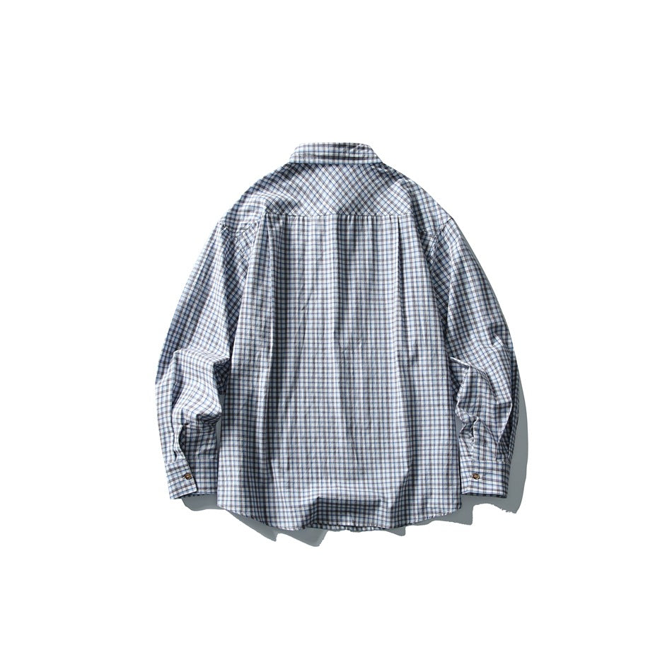 Back view of blue, white and brown plaid long-sleeve shirt laid flat showing yoke and buttoned cuffs
