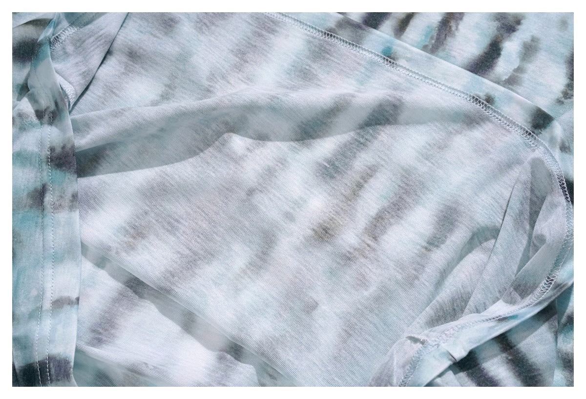 Close-up of the inside of tie-dye fabric, showing overlocked seams and stitching.