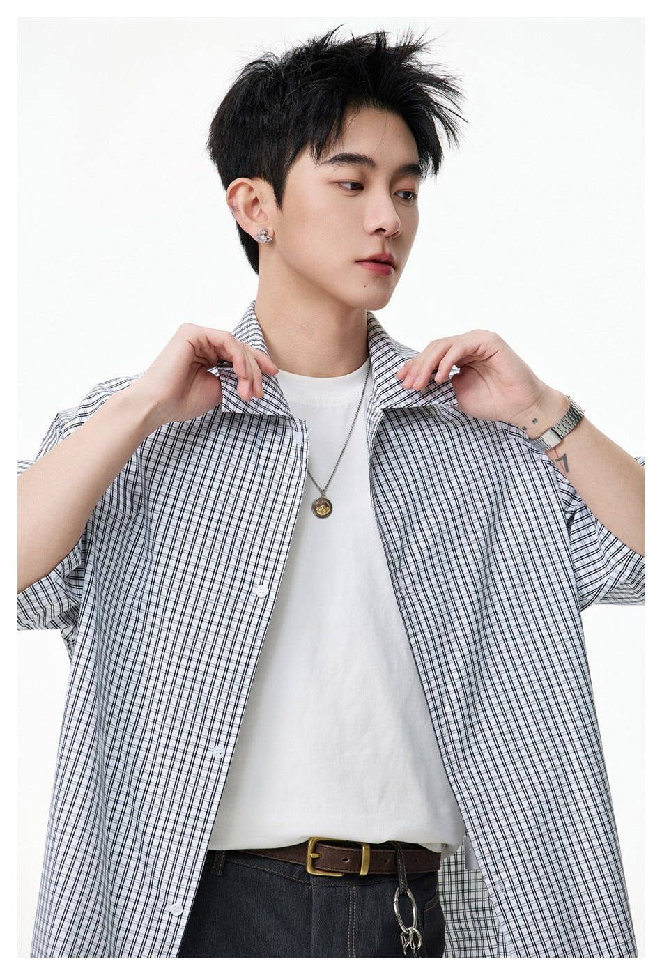Close-up of a model wearing an open white shirt with a black windowpane check over a white T-shirt.