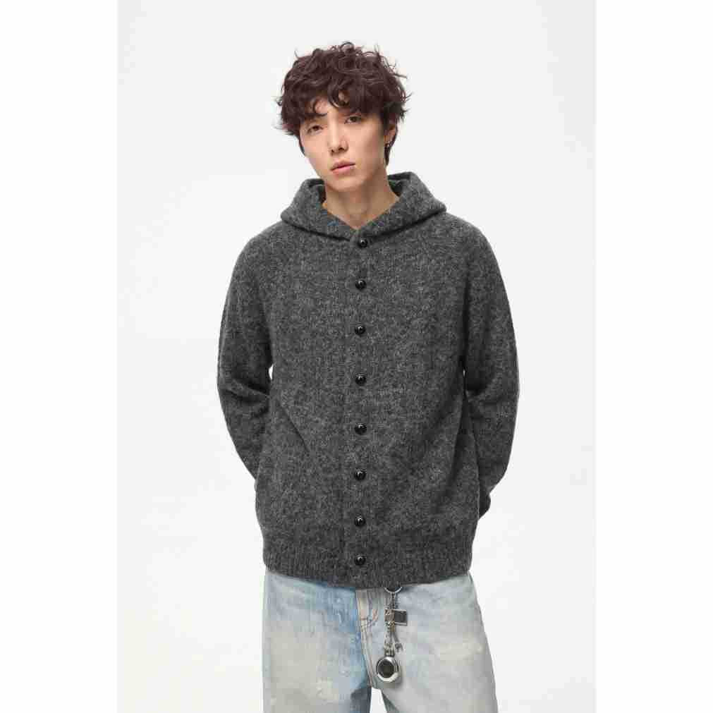 Model wearing a charcoal hooded cardigan with black buttons, shown from the waist up.