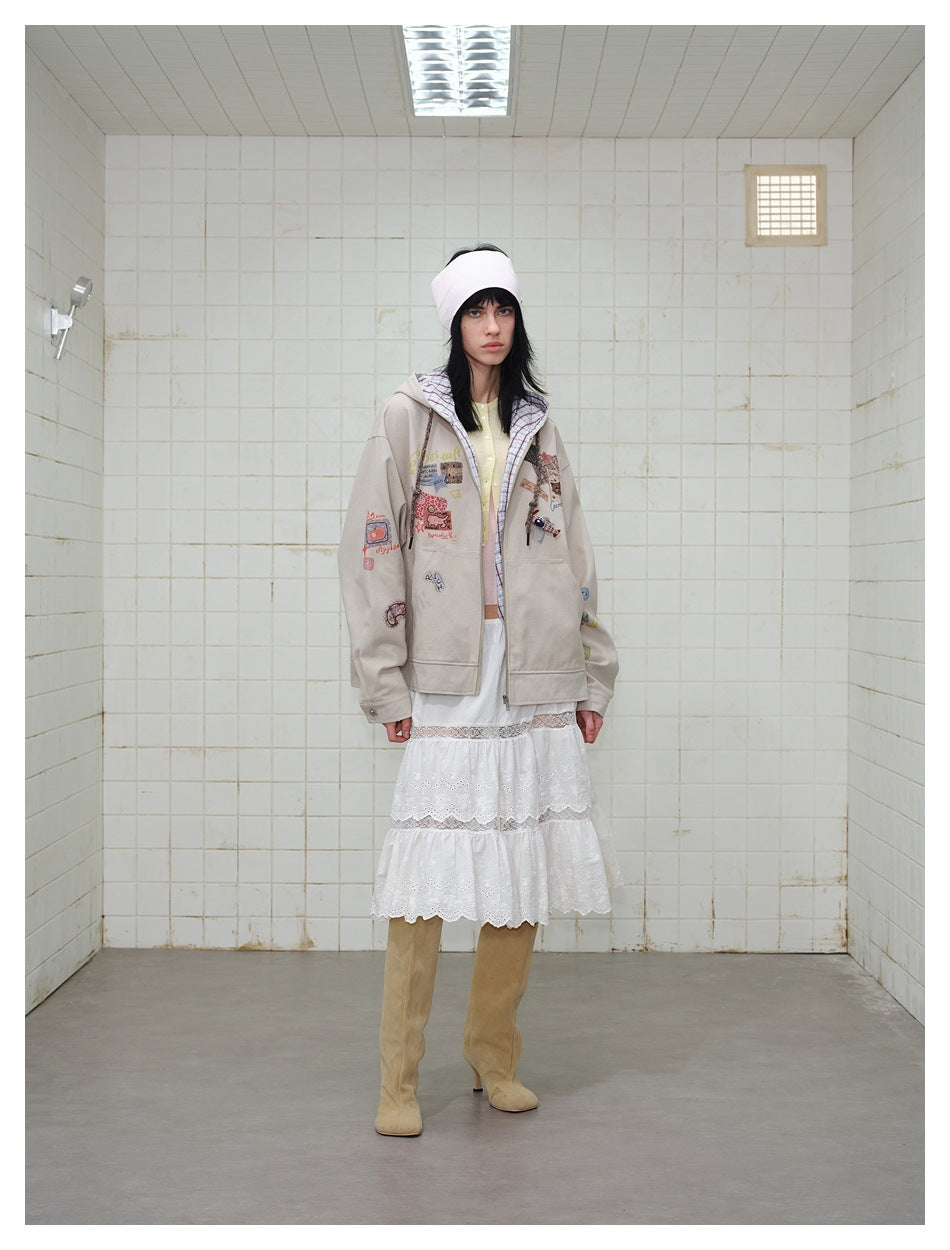 Full-length model wearing a patched beige hooded jacket, pale yellow cardigan, white lace skirt, and tan boots.