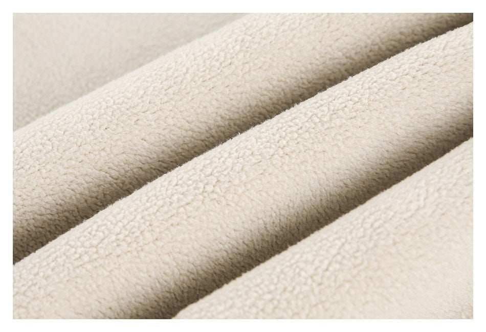 Macro view of plush cream fabric arranged in soft diagonal folds.