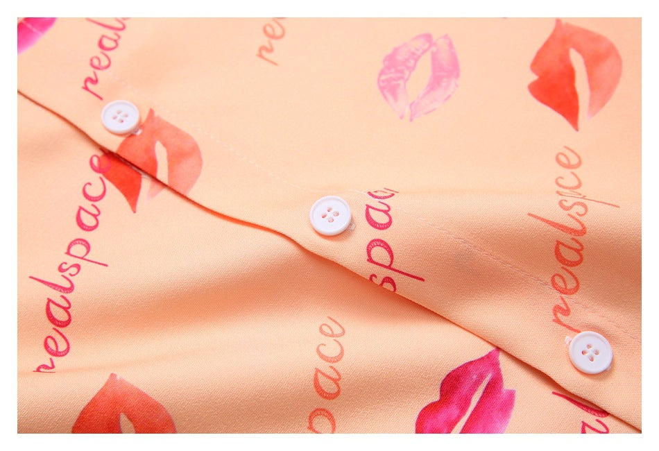 Close-up of the peach garment's button front with white buttons and a pink lip print.