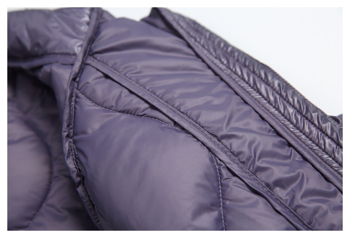 Close-up of dark purple glossy quilted lining, showing curved seams and bound edges.