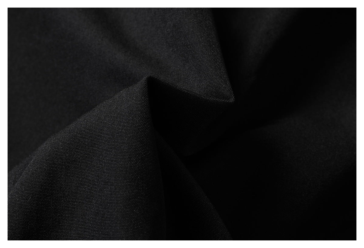 Close-up of black fabric folded to show its smooth surface and drape.