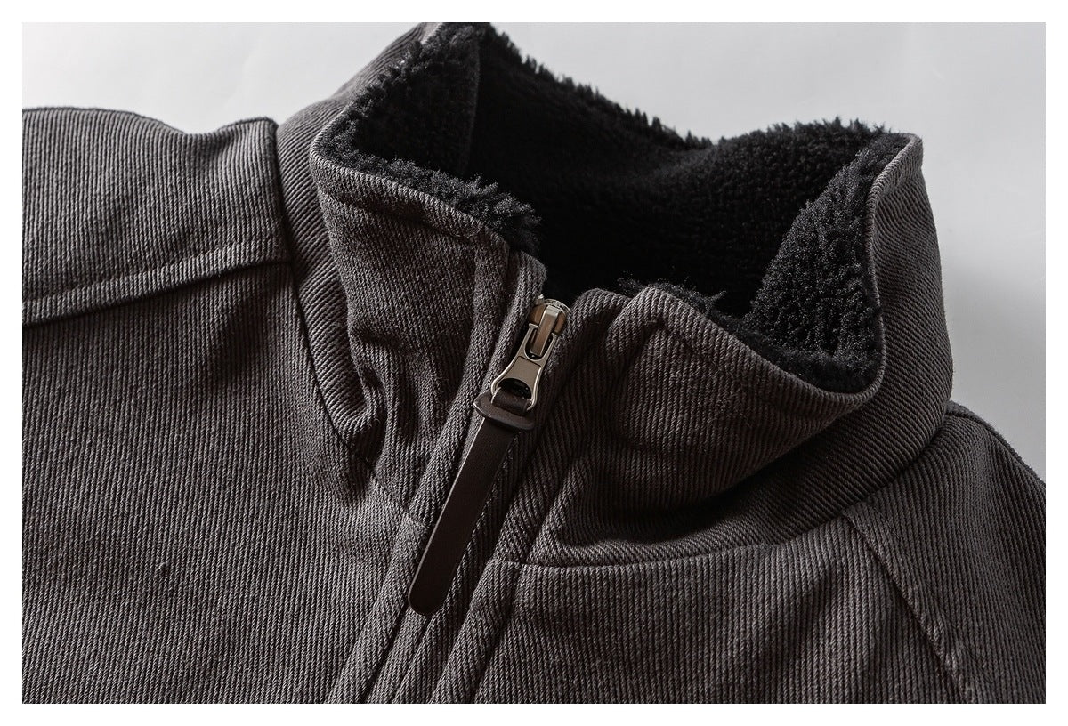 Close-up of a charcoal jacket's raised collar, black fleece lining, and zipper.