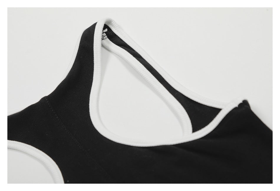 Close-up of the black garment's white-bound neckline and shoulder strap.