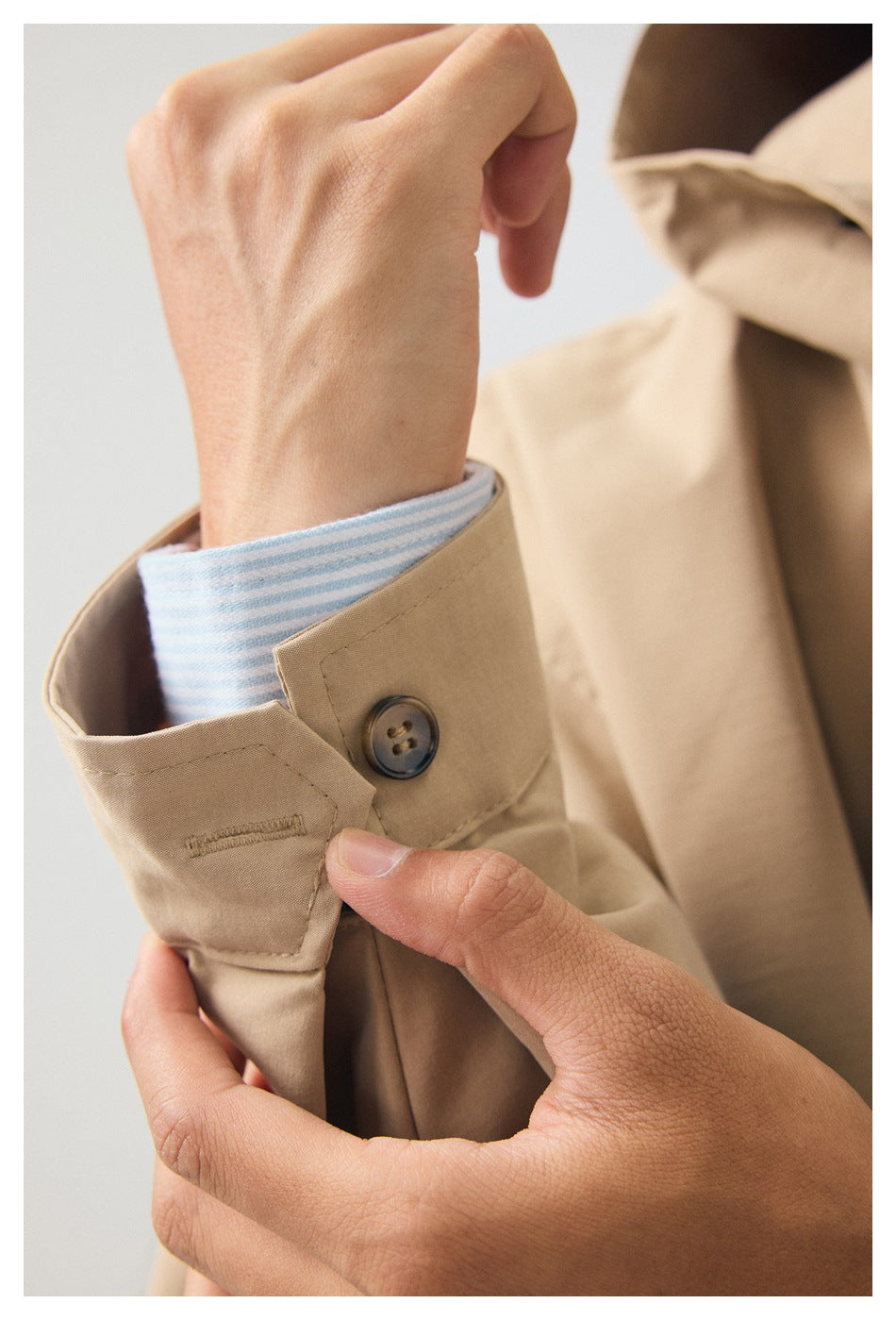Close-up of the beige coat cuff with a dark button and buttonhole detail.