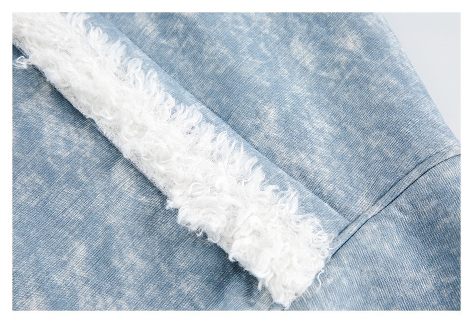 Close-up of a white curly trim edge against light blue denim.