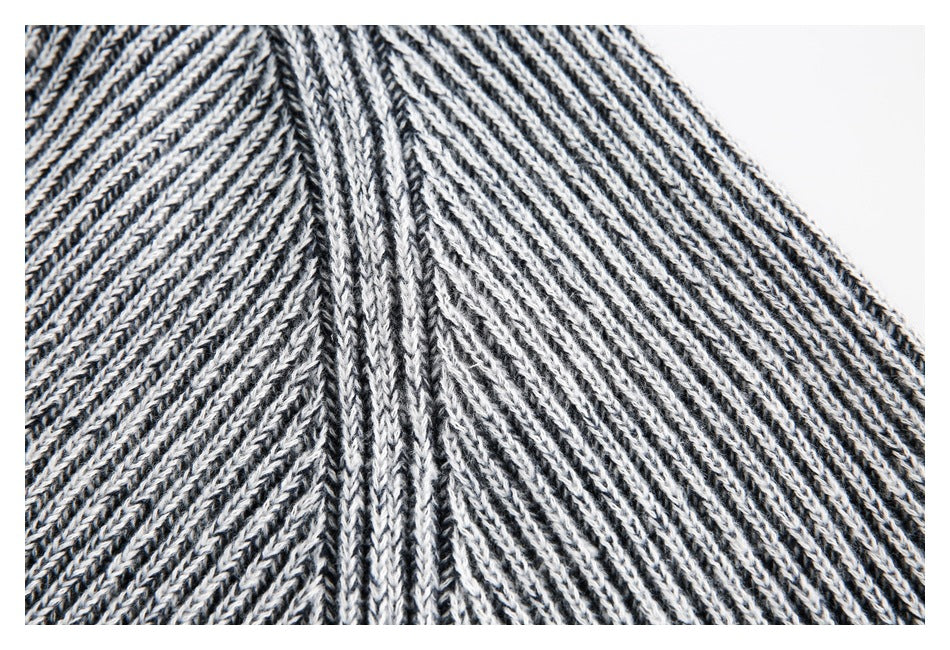 Close-up of the sweater's shoulder seam, showing black-and-white marled knit stitches.