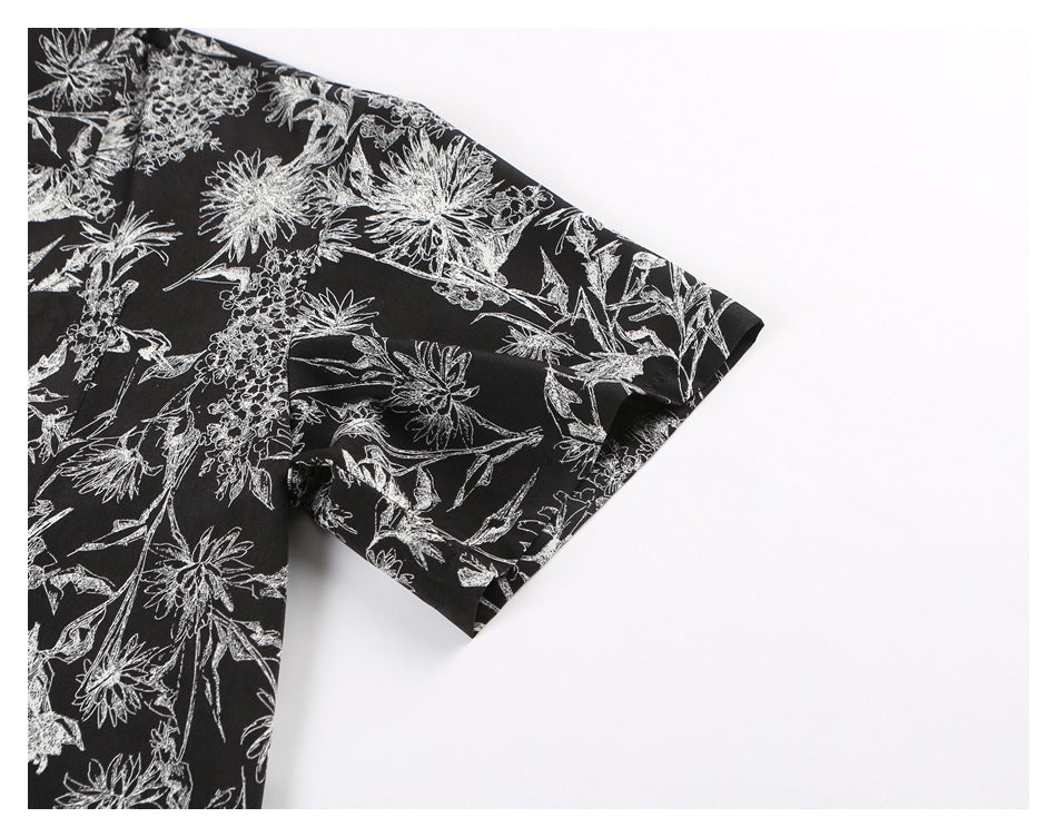 Close-up of the short sleeve of a black shirt with white floral print.