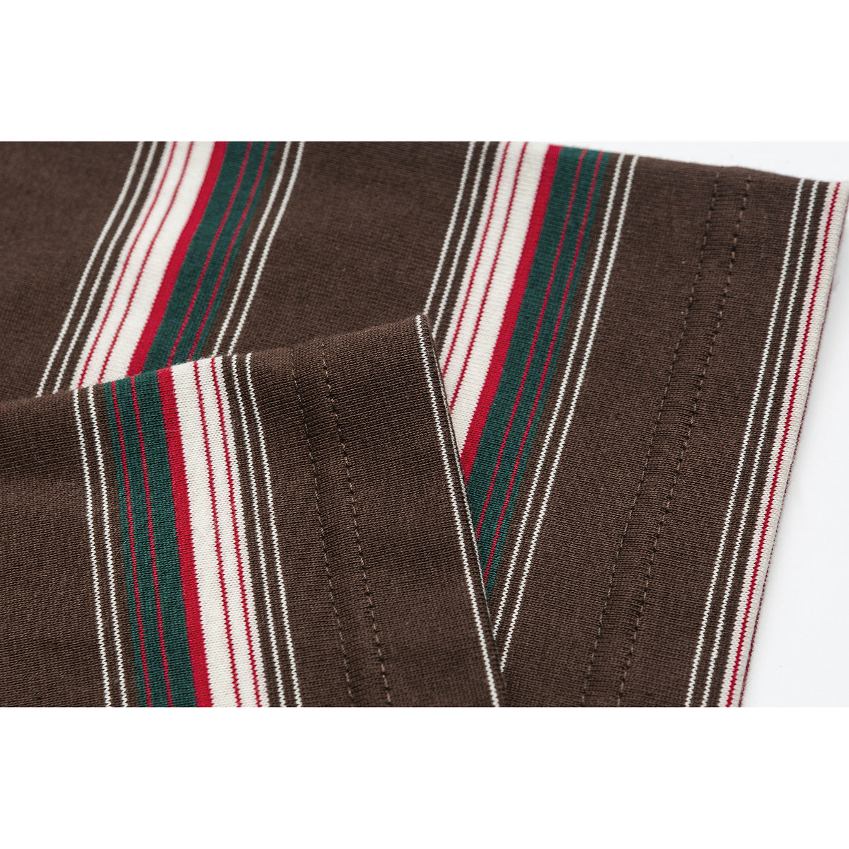 Close-up of the brown knit top's striped sleeve cuff and stitched hem.