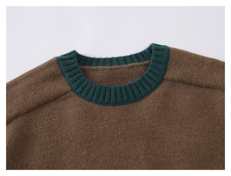 Close-up of a brown knit sweater with a dark teal ribbed crew neckline.