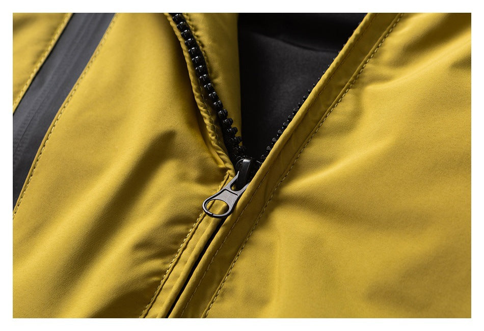 Close-up of the jacket’s black front zipper and teeth against mustard yellow fabric and black lining.