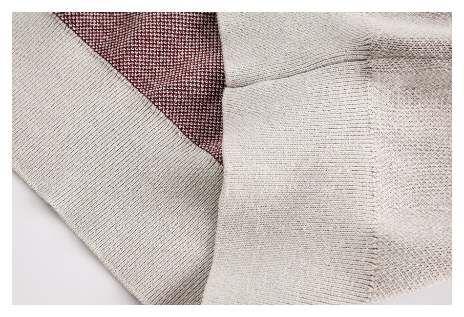 Close-up of the cream sweater's ribbed seam and contrasting red-and-cream knit inside.
