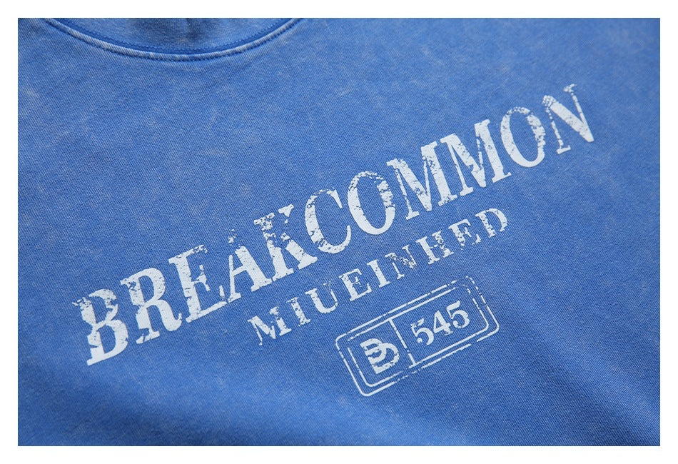 Close-up of distressed white English lettering and a small graphic printed on a blue T-shirt.