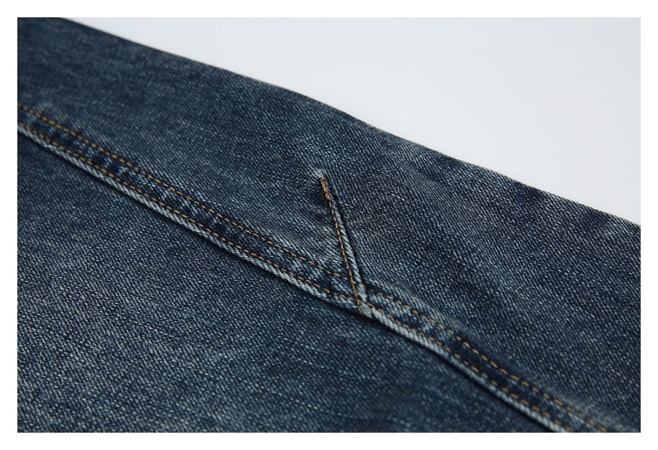 Close-up of a long stitched seam across dark blue denim.