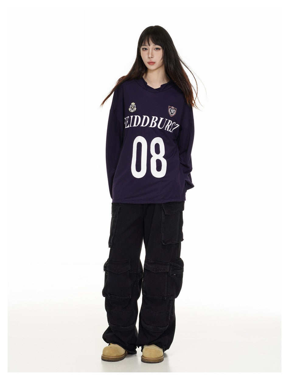Full-length front view of a model wearing a dark navy hooded jersey with crest graphics and a large white 08.