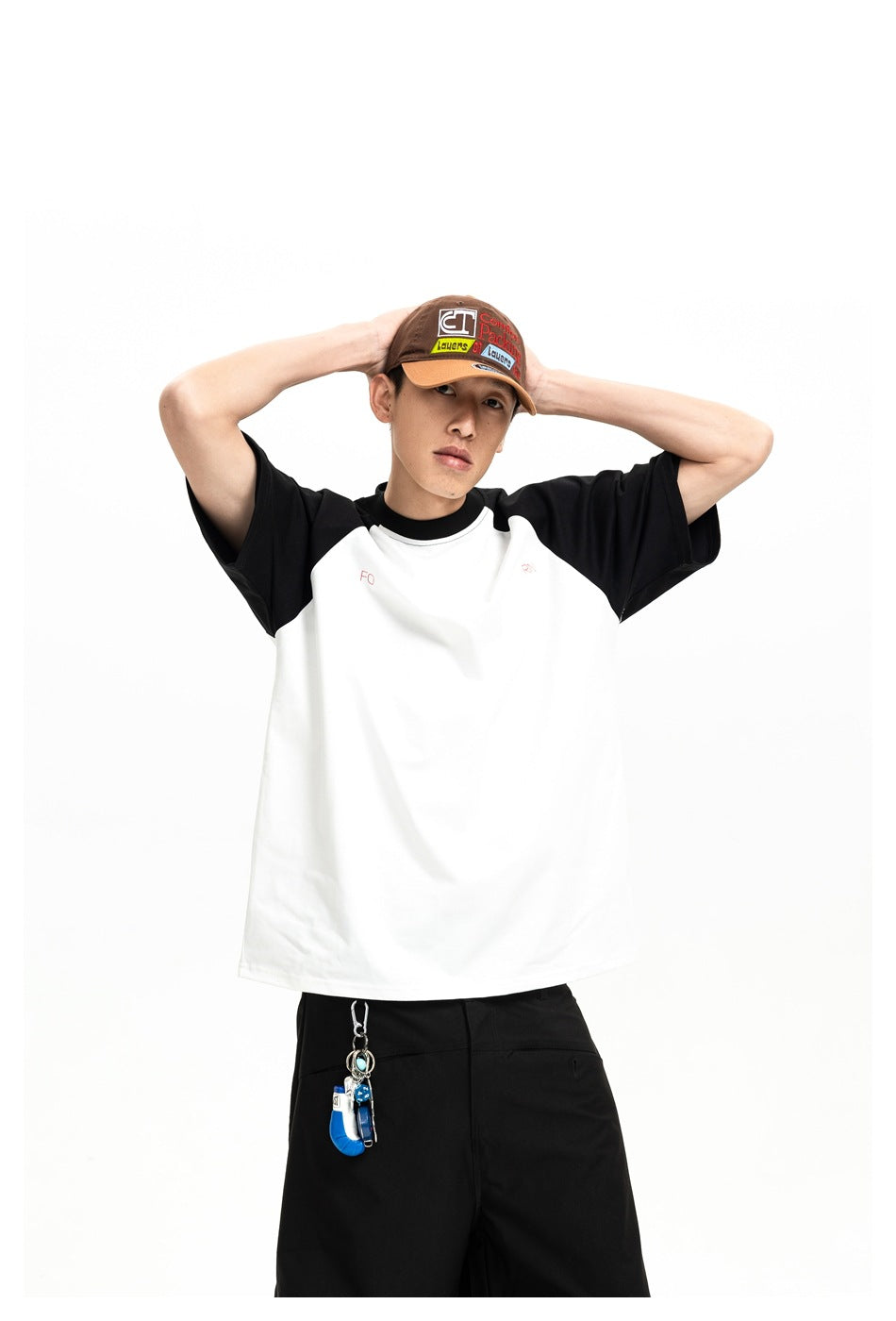 Model wearing a white raglan T-shirt with black sleeves and collar, shown from the front.