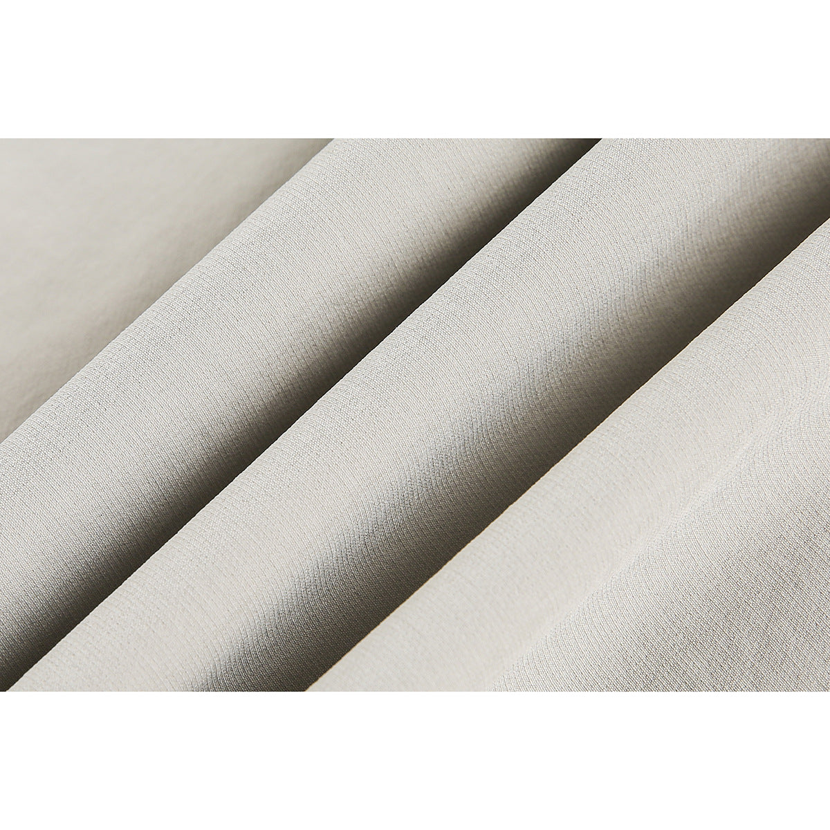 Close-up of light beige fabric arranged in soft folds, showing its fine surface texture.