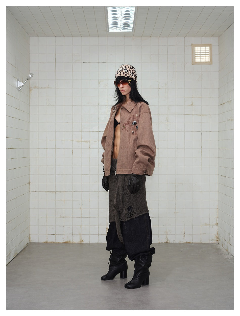 Model wearing a brown jacket with a zip front and decorative buttons, shown at an angle.