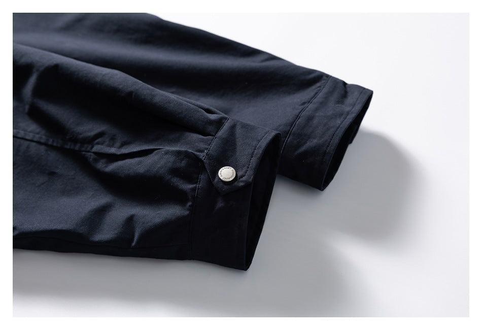 Close-up of a dark navy jacket sleeve cuff with a silver snap tab.