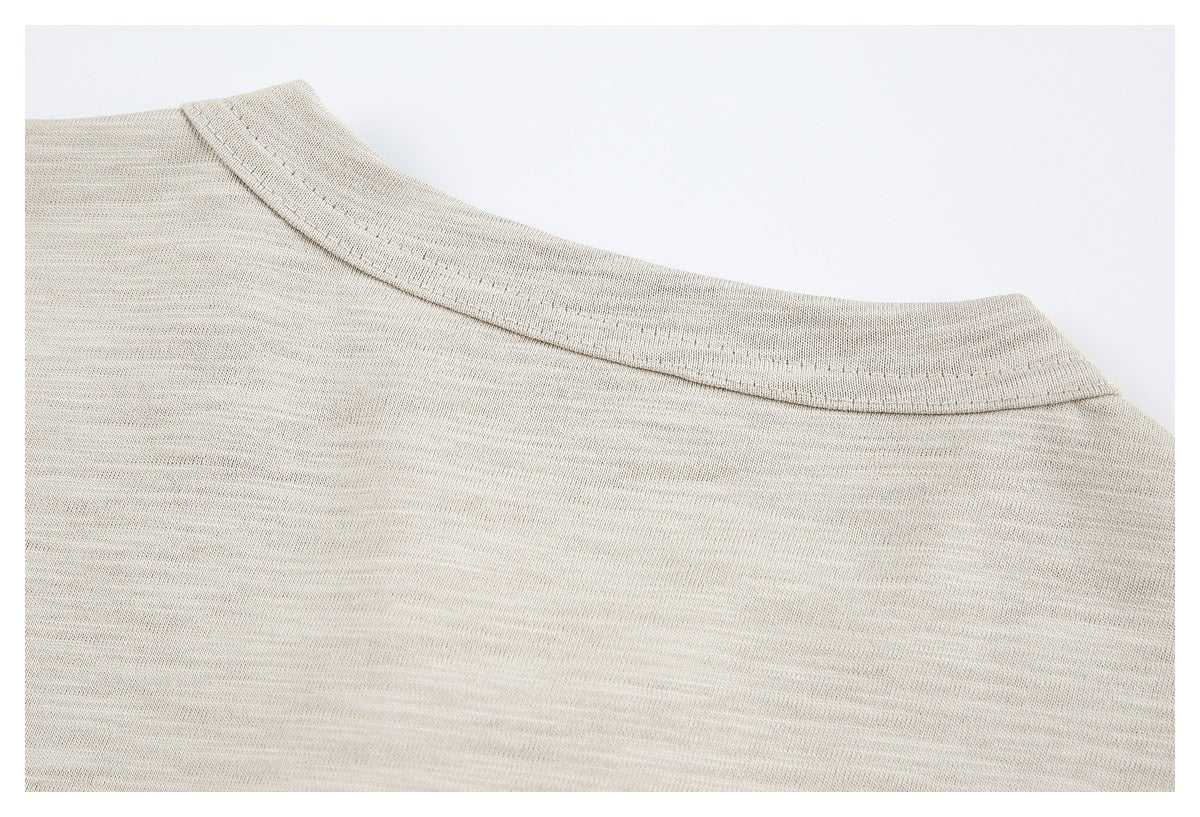 Close-up of the rounded neckline and double stitching on a beige heathered top.
