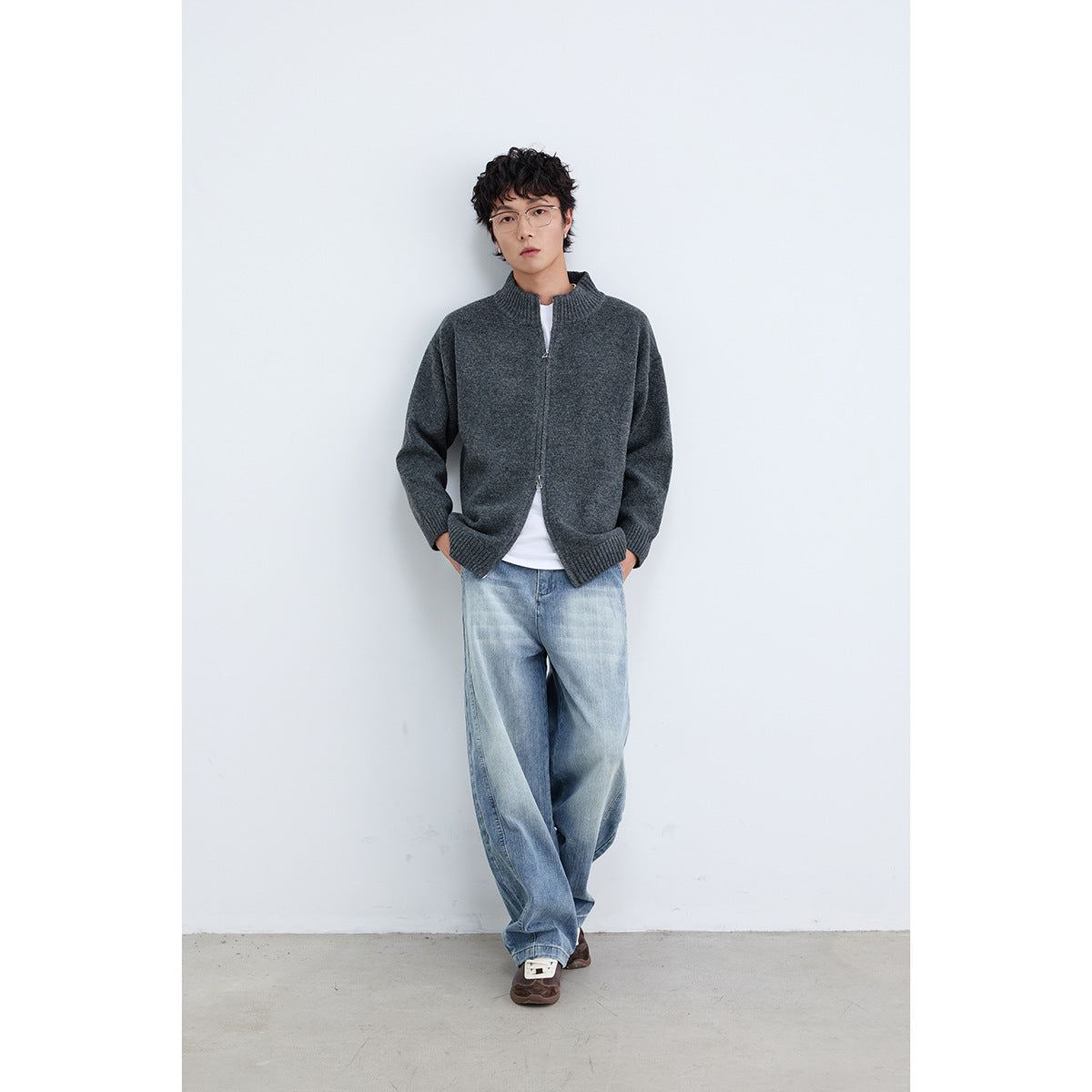 Model wearing a charcoal gray zip-front cardigan with a ribbed stand collar and wide-leg jeans.