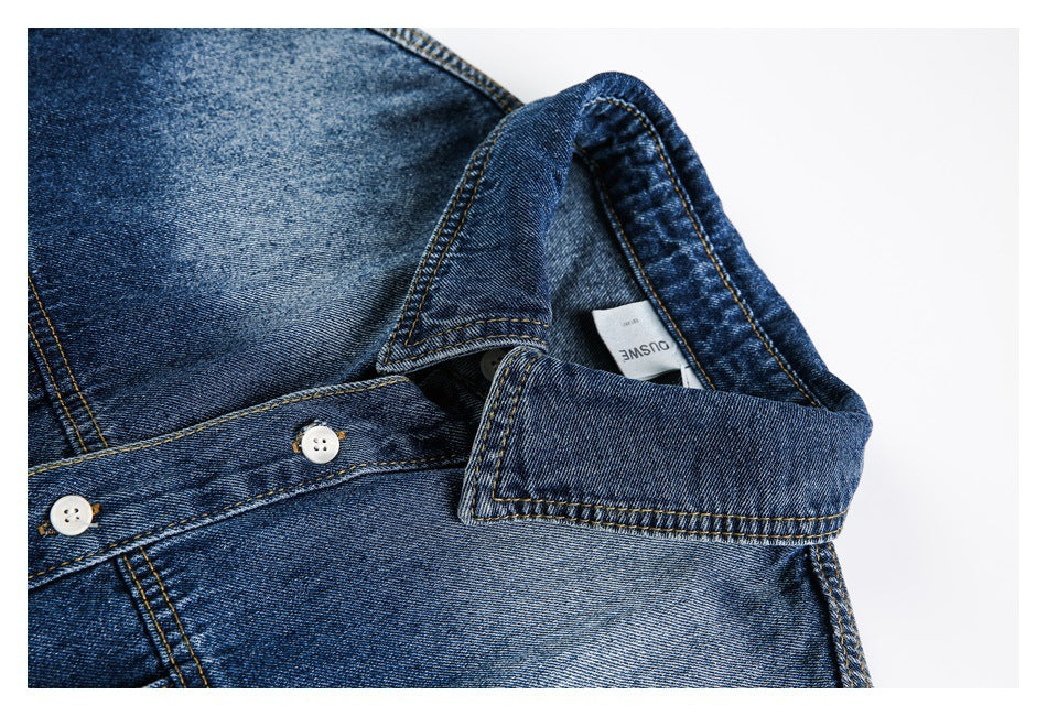 Close-up of a dark blue denim shirt collar and placket with contrast stitching and white buttons.