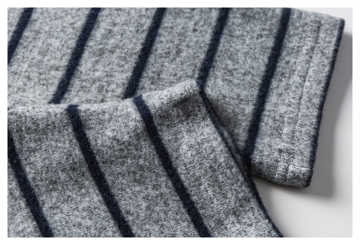 Close-up of a striped sleeve cuff and folded gray fabric showing the hem stitching.
