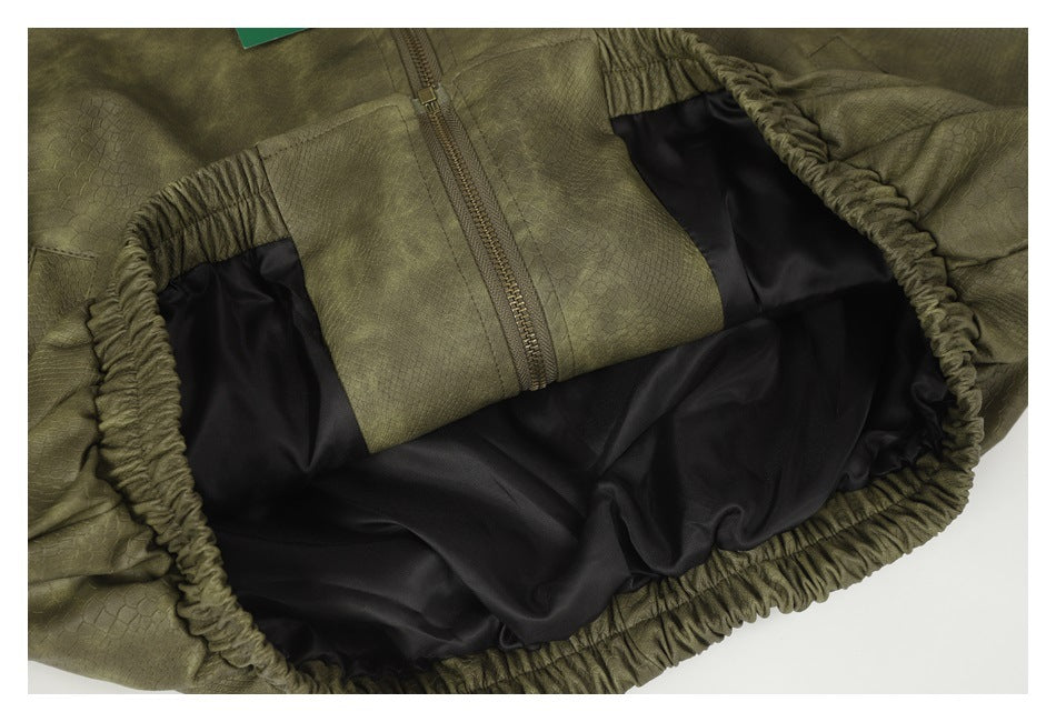 Close-up of an olive-green garment's elastic opening, black lining, and zipper area.