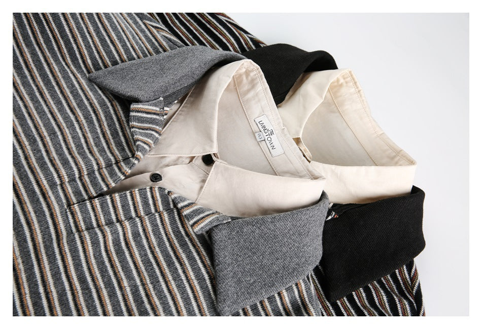 Close-up of striped pullover collars in gray and black, layered over a cream collared shirt.