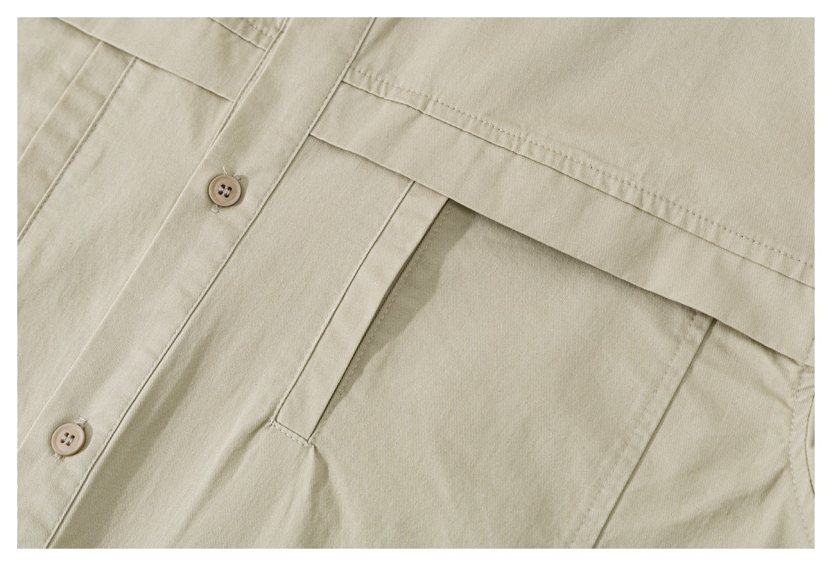 Close-up of a beige shirt button placket and large stitched pocket.