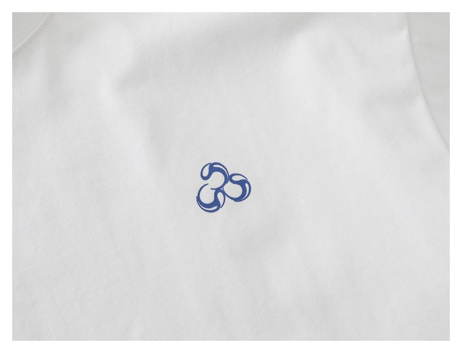Close-up of a small blue emblem printed on the white T-shirt.