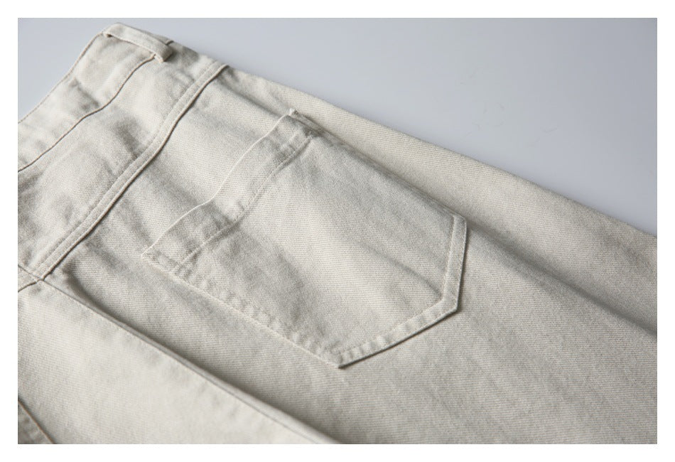 Close-up of a light beige trouser back pocket with angled corners and visible stitching.