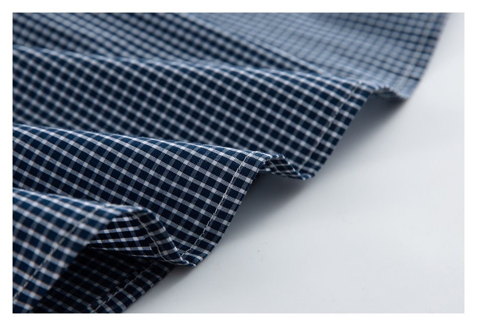 Close-up of the checked shirt's stitched edge and hem.