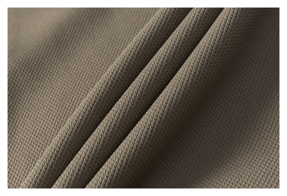 Macro view of taupe textured fabric arranged in folds.