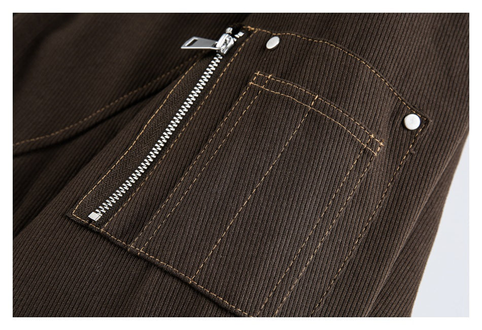 Close-up of a brown jacket pocket with a vertical zipper, metal snaps, and tan contrast stitching.
