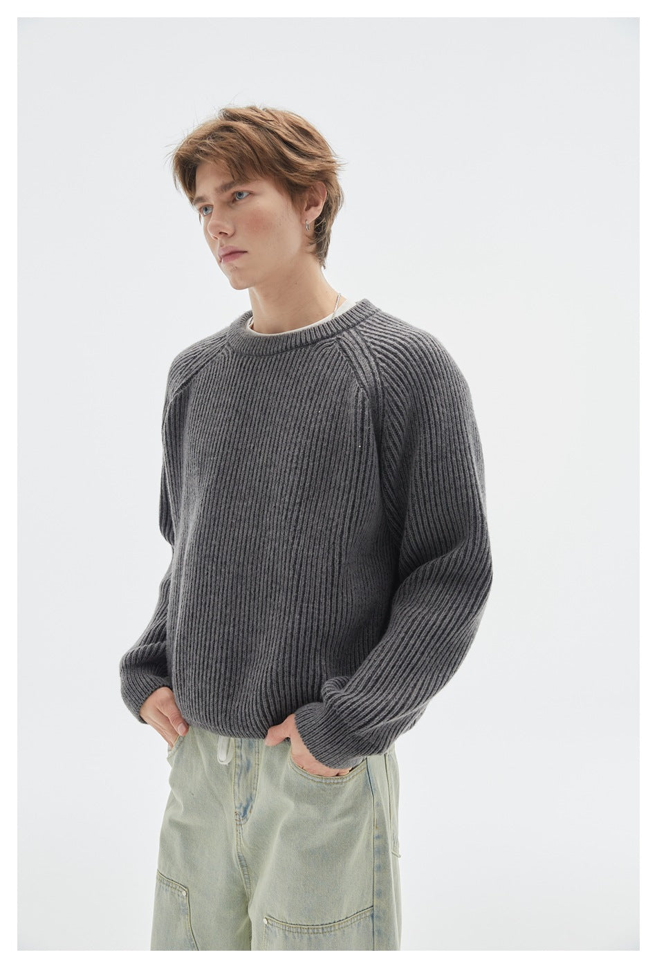 Model wearing a dark gray ribbed raglan sweater with pale green jeans, shown from the front.