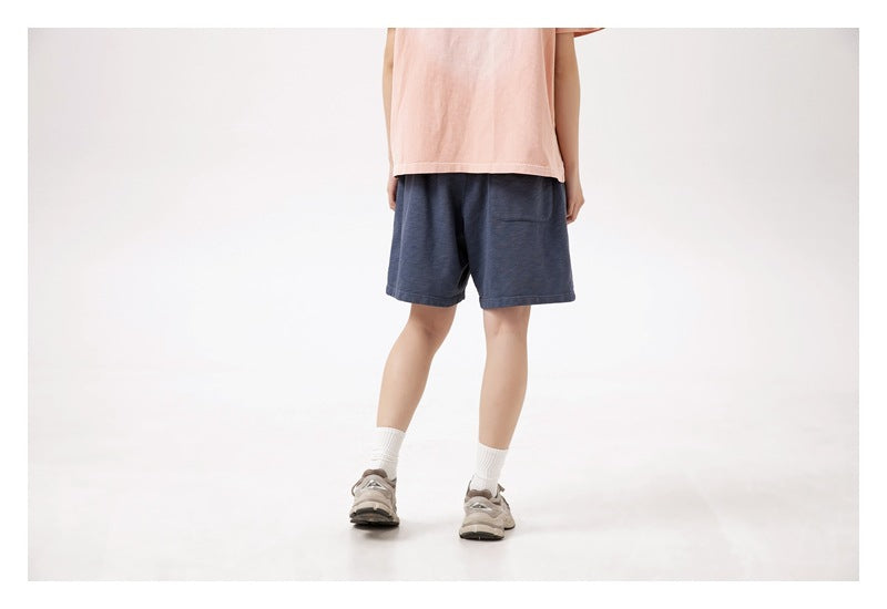Back view of a model wearing navy blue shorts with a rear pocket.