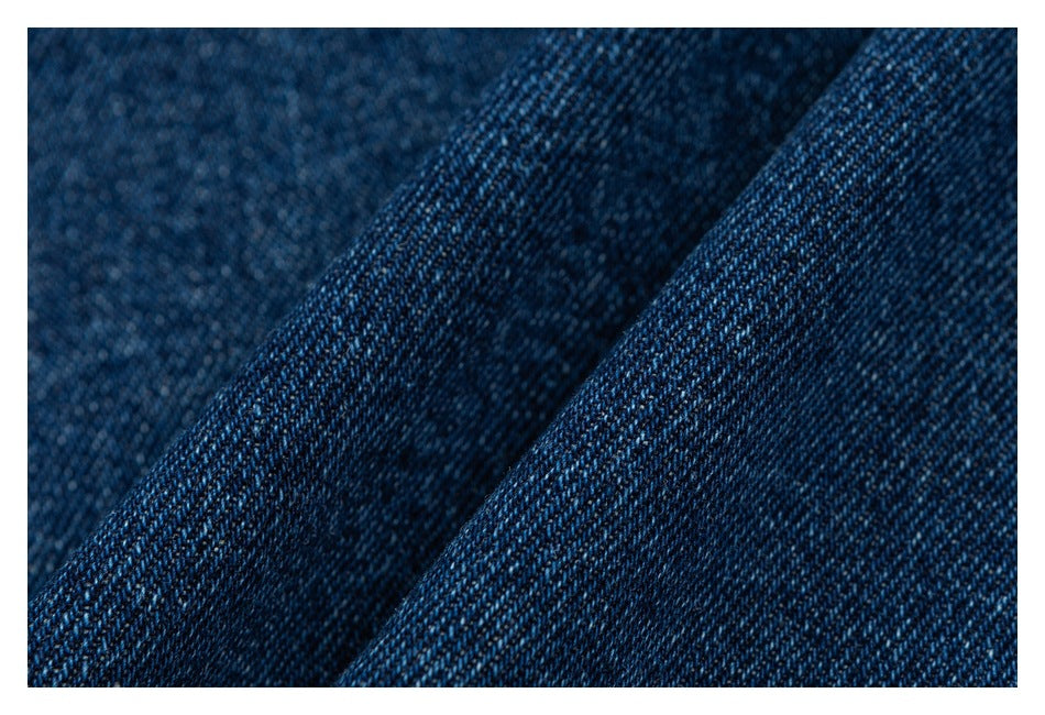 Macro close-up of the dark blue denim weave and folded fabric.