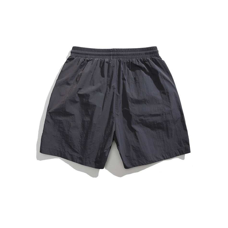 Back view of charcoal shorts with an elastic waistband and a single rear patch pocket.